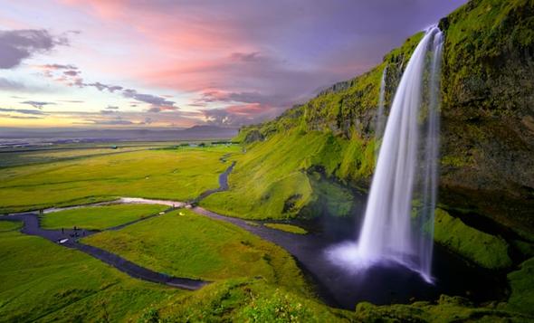 The breathtaking Seljalandsfoss waterfall at sunset. As tourism booms around natural landmarks like this, adhering to the "90/2M rule" allows hosts to share Iceland’s beauty with guests while respecting local housing regulations.