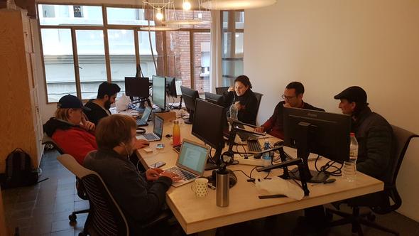 Early Hostaway employees sit around a table of monitors and computers in 2018