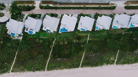 A bird's-eye perspective of prime beachfront vacation rental properties illustrating how location, curb appeal, and proximity to desirable amenities like the beach directly influence occupancy rates. This type of imagery reinforces the importance of multi-channel distribution — properties in high-demand locations benefit from visibility across Airbnb, Vrbo, and direct booking sites to capture every possible reservation and minimize vacancy.