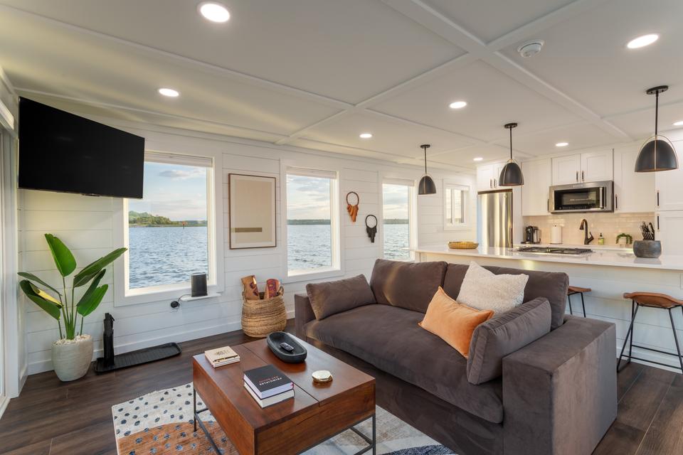 FLOHOM’s tiny house living room, styled with simplicity and large windows, provides a warm and tranquil space for guests to enjoy the scenic waterfront.