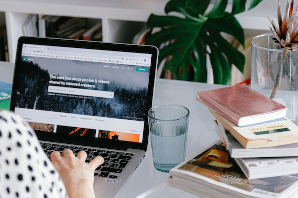 Property manager using laptop to create direct booking website with customizable templates, integrated payment processing, and real-time availability calendar for vacation rentals